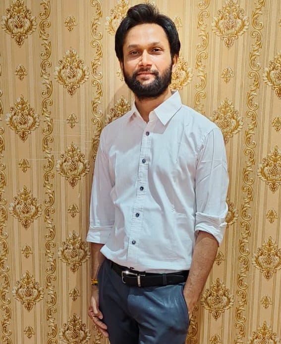 Portrait of Dr Amit, Ayurvedic Practice Advisor, in a white shirt.